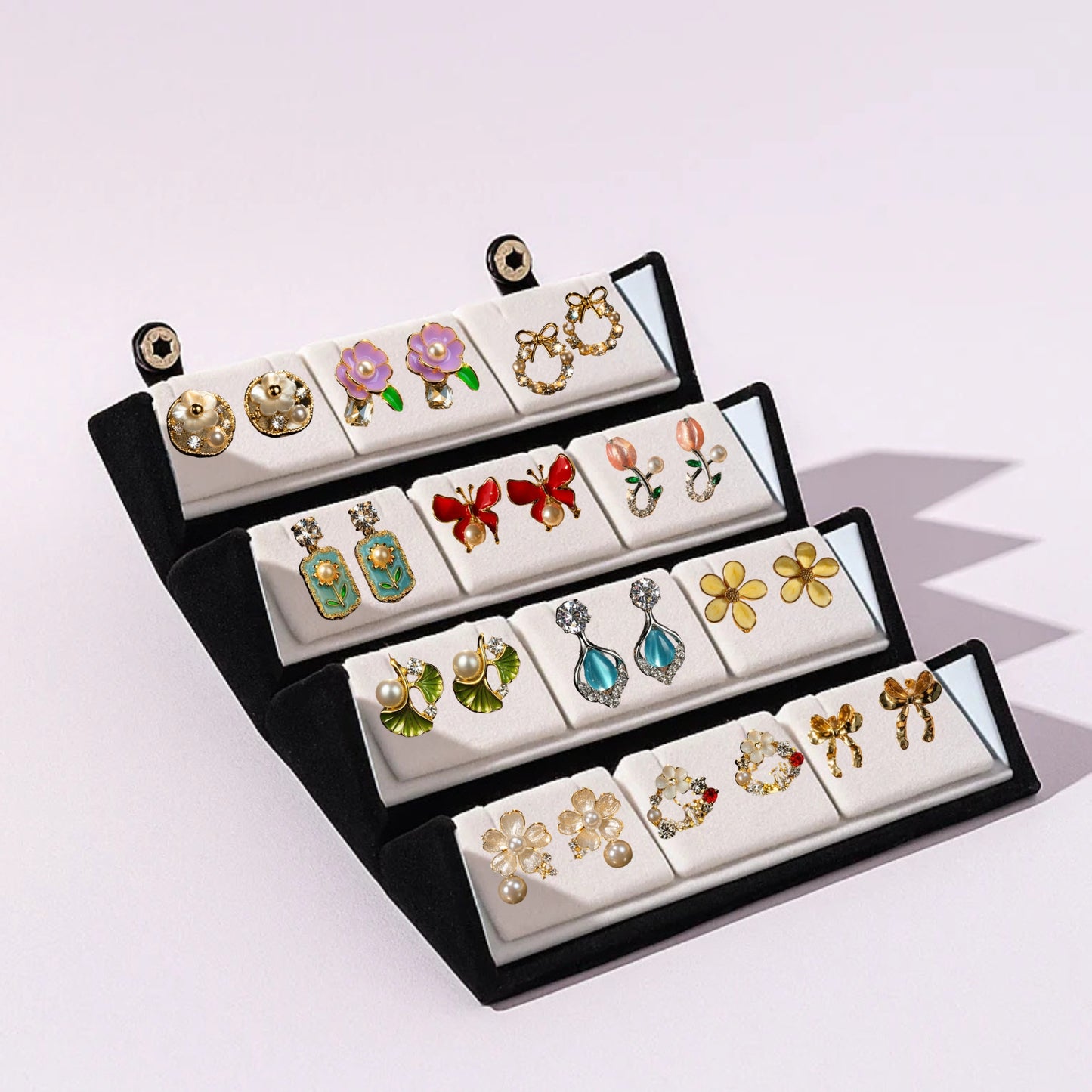 Set of colorful earrings in a black jewelry box on a white background