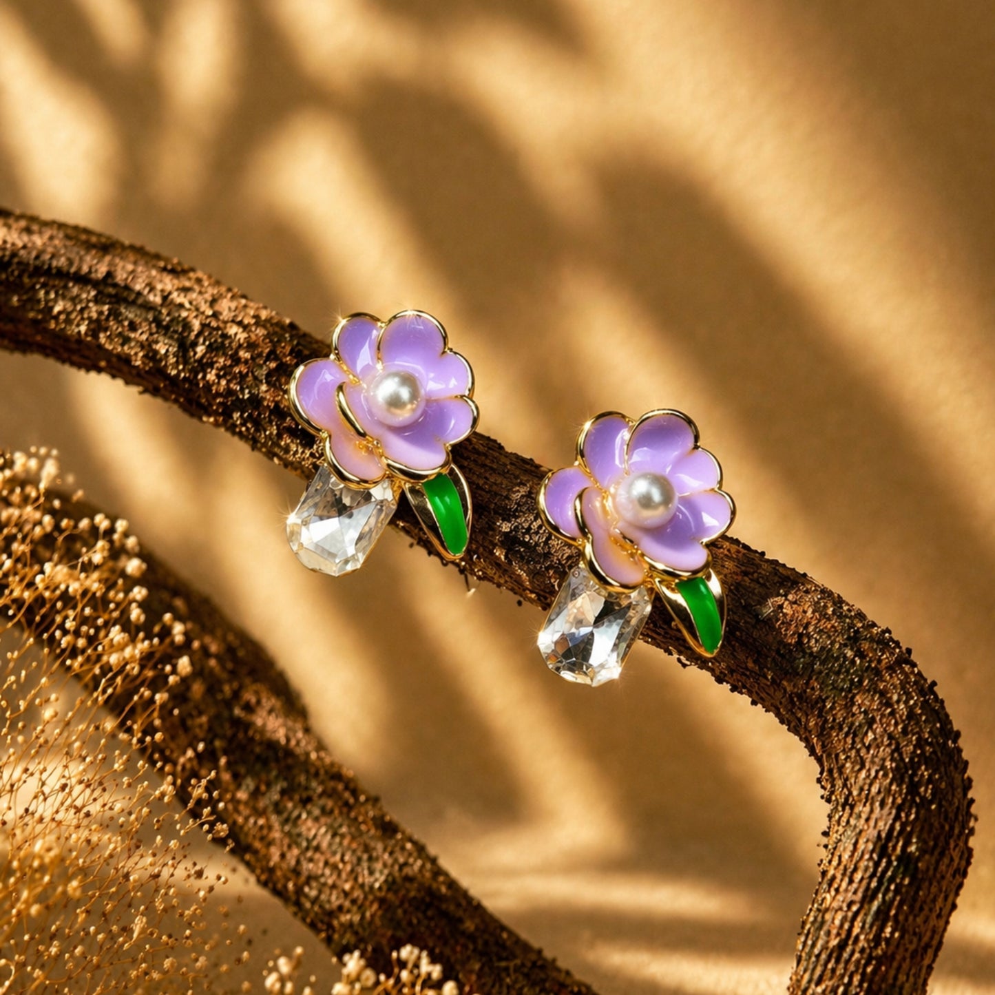 Flower-shaped earrings with purple flowers and pearl centers on a branch with a natural background.